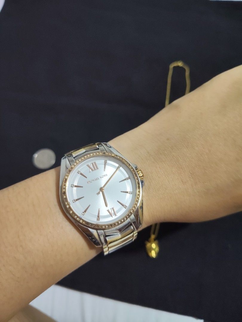 Michael Kors Two-Tone Chevron Bracelet Watch (Category: Women's Watches) located in San Pablo. Submitted by leogirlshel (Listing ID 1469642762, Image 3). Description: Michael Kors watch with a round white dial, Roman numerals at twelve and six, and crystal markers around the bezel. Two-tone gold and silver chevron link bracelet with a fold-over clasp engraved with the Michael Kors logo. Shows minor surface wear on the metal links from regular use