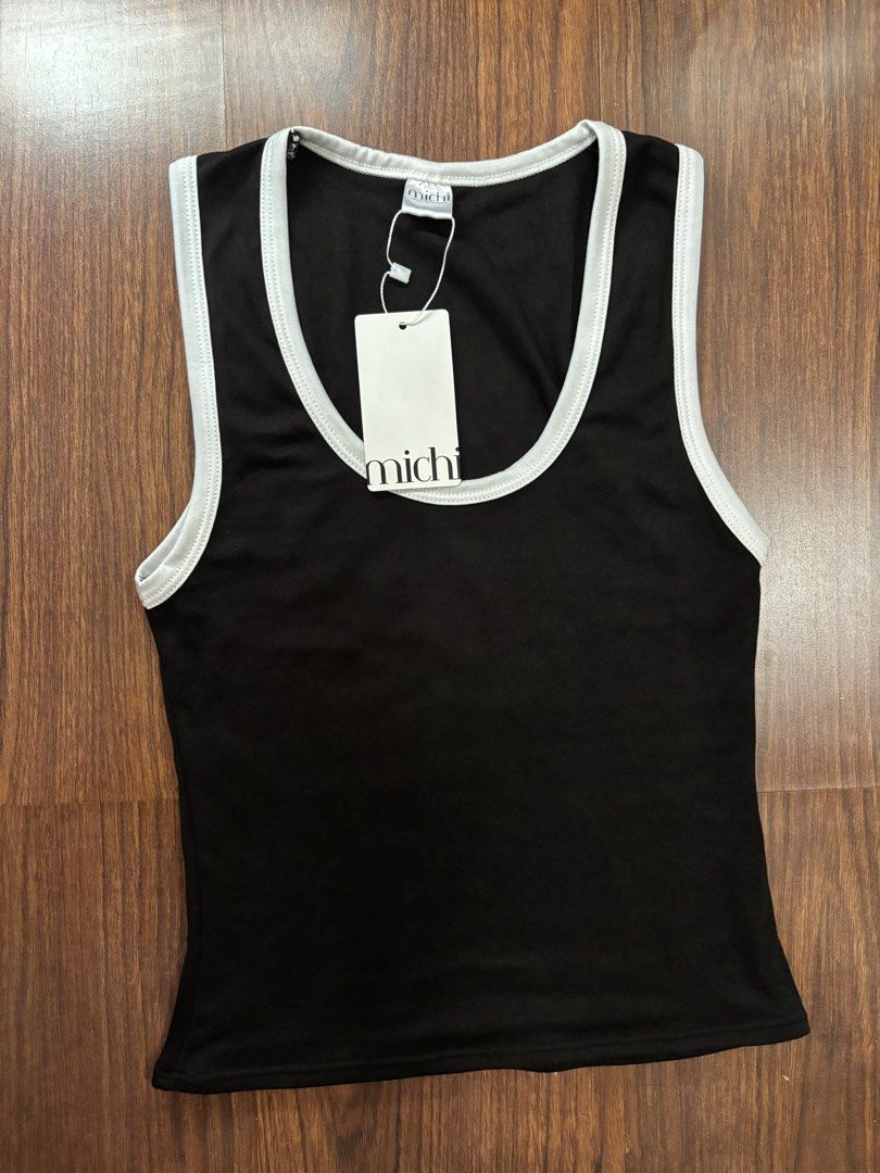 Michi Black White Ringer Tank Top (Category: Sleeveless) located in San Juan City. Submitted by hellokitty_454 (Listing ID 1469621772, Image 2). Description: - Brand: Michi - Condition: Brand new with tags (BNWT) - Color: Black with contrast white ribbing on neckline and armholes - Neckline: Scoop neck - Material: Soft and stretchy fabric - Perfect for casual wear or layering.