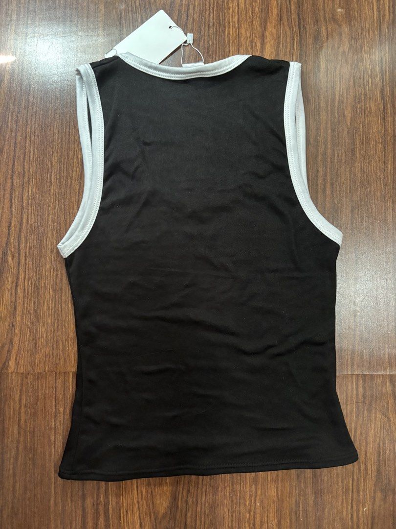 Michi Black White Ringer Tank Top (Category: Sleeveless) located in San Juan City. Submitted by hellokitty_454 (Listing ID 1469621772, Image 3). Description: - Brand: Michi - Condition: Brand new with tags (BNWT) - Color: Black with contrast white ribbing on neckline and armholes - Neckline: Scoop neck - Material: Soft and stretchy fabric - Perfect for casual wear or layering.