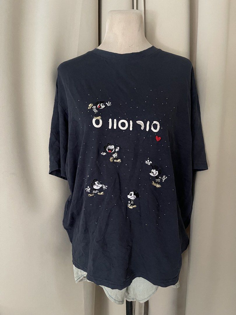 Mickey Embroidered Dark Blue (Category: Shirts) located in Cainta. Submitted by zlove111 (Listing ID 1469620101, Image 1). Description: - Color: Dark blue cotton xl 22" - Design: All-over embroidered Mickey Mouse graphics with white text and silver rhinestone studs - Detail: Small red heart patch near the center - Fit: Relaxed fit with short sleeves - Style: Great casual piece for Disney fans.