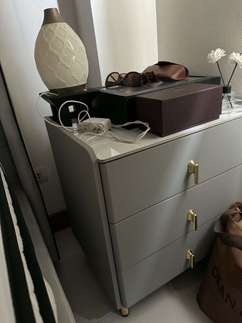 Modern 3-Drawer Bedside Table with Gold Handles (Category: Shelves, Cabinets & Racks) located in Makati City. Submitted by kdclueless (Listing ID 1469620053, Image 1). Description: Set of 2 P 4900 - Style: Modern and minimalist design that fits contemporary rooms - Storage: 3 spacious drawers for bedroom essentials, books, and accessories - Finish: Soft grey body paired with elegant gold handles and legs - Surface: Chic white marble-patterned top