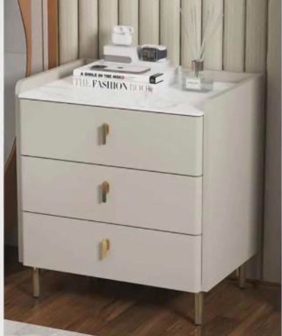 Modern 3-Drawer Bedside Table with Gold Handles (Category: Shelves, Cabinets & Racks) located in Makati City. Submitted by kdclueless (Listing ID 1469620053, Image 2). Description: Set of 2 P 4900 - Style: Modern and minimalist design that fits contemporary rooms - Storage: 3 spacious drawers for bedroom essentials, books, and accessories - Finish: Soft grey body paired with elegant gold handles and legs - Surface: Chic white marble-patterned top