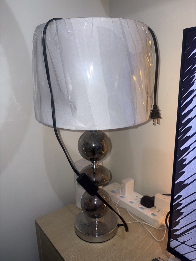 Modern Table Lamp with Stacked Glass Spheres (Category: Lighting) located in Manila. Submitted by rodriguesyb (Listing ID 1469638249, Image 1). Description: - Elegant design featuring 3 stacked smoked glass spheres - Sturdy chrome base with a flat, round stand - Topped with a white fabric shade (protective plastic wrap still attached) - Convenient black power cord with an inline toggle switch - Perfect size for bedside nightstands or office desk 