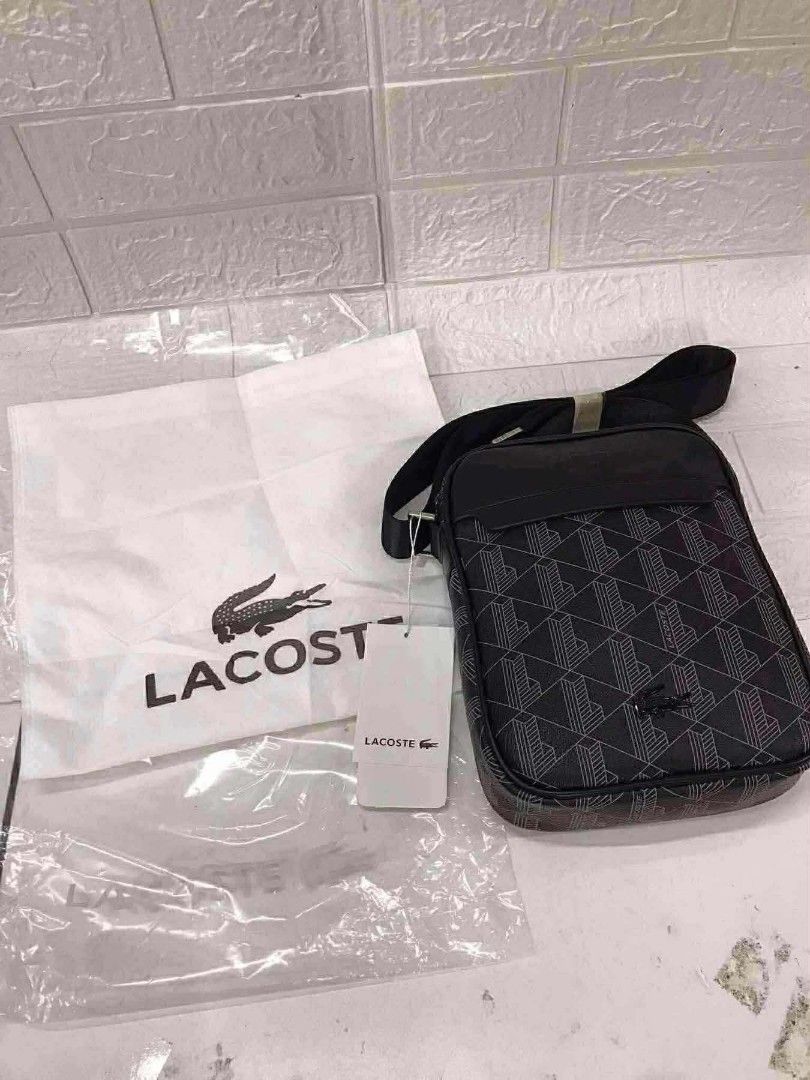 Monogram Print Crossbody Bag Black (Category: Sling Bags) located in Manila. Submitted by prime.dlor (Listing ID 1469743106, Image 2). Description: - Authentic Lacoste crossbody bag in black - Features a stylish geometric monogram pattern with smooth leather top panel - Silver-tone hardware with iconic embossed branding and tiny crocodile zipper pull - Adjustable black shoulder strap for comfortable wear - Includes original white dust bag and pap