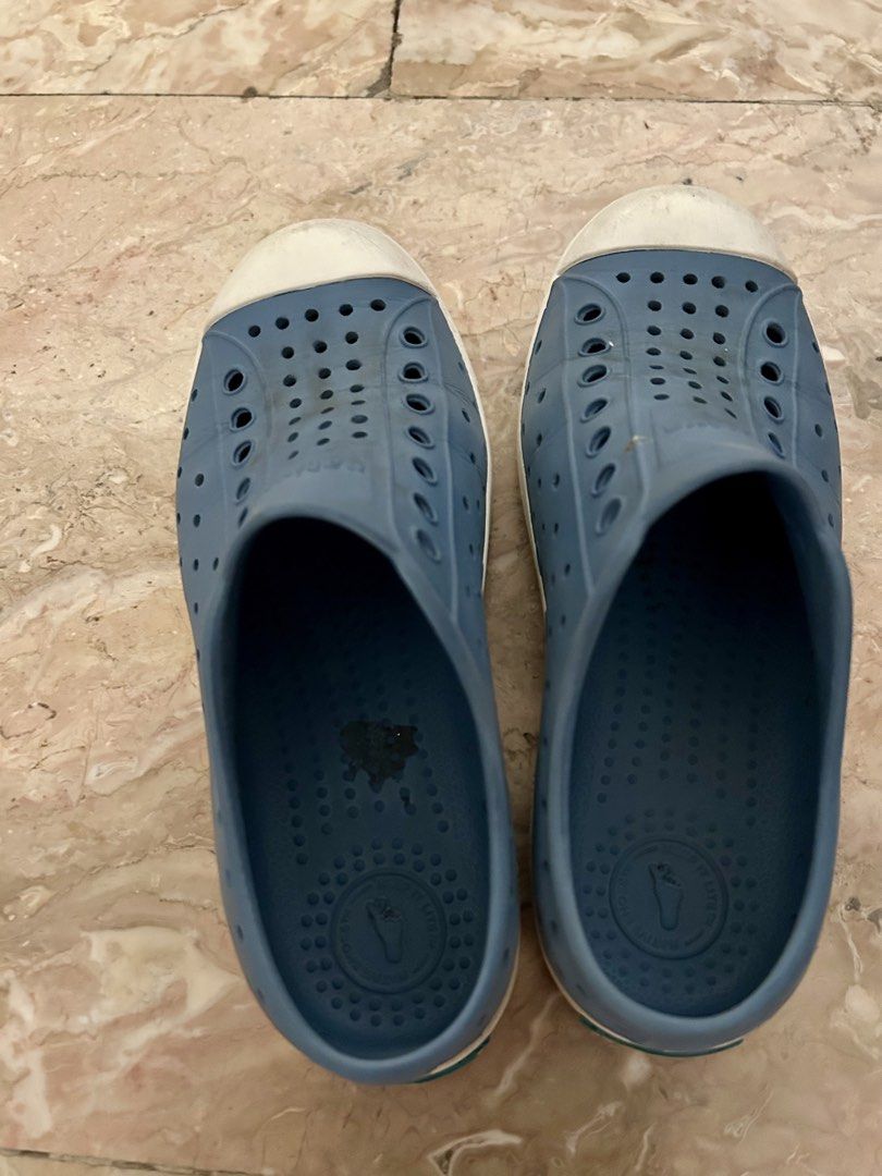 Native Shoes Jefferson Child Size C13 Blue (Category: Babies & Kids Fashion) located in Quezon City. Submitted by poaimommy (Listing ID 1469581714, Image 3). Description: - Brand/Model: Native Jefferson Kids Slip-On Shoes - Color: Blue with white toe caps - Size: C13 (stamped on soles) - Material: Lightweight, perforated EVA for airflow and quick drying - Condition: Moderate tread wear and scuff marks on toe bumpers from normal use - Features: Ea