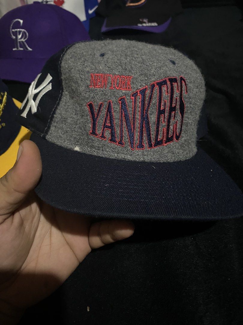 New York Yankees Wool Snapback Cap Grey Navy (Category: Caps & Hats) located in Naga. Submitted by salakot4400 (Listing ID 1469742854, Image 1). Description: - Style: Classic flat brim snapback - Design: Grey wool crown with a contrasting navy blue brim - Embroidery: Large Yankees text in navy and red on the front, with a small side logo - Quality: Clean texture and solid stitching all around - Condition: Well-maintained and ready to wear.