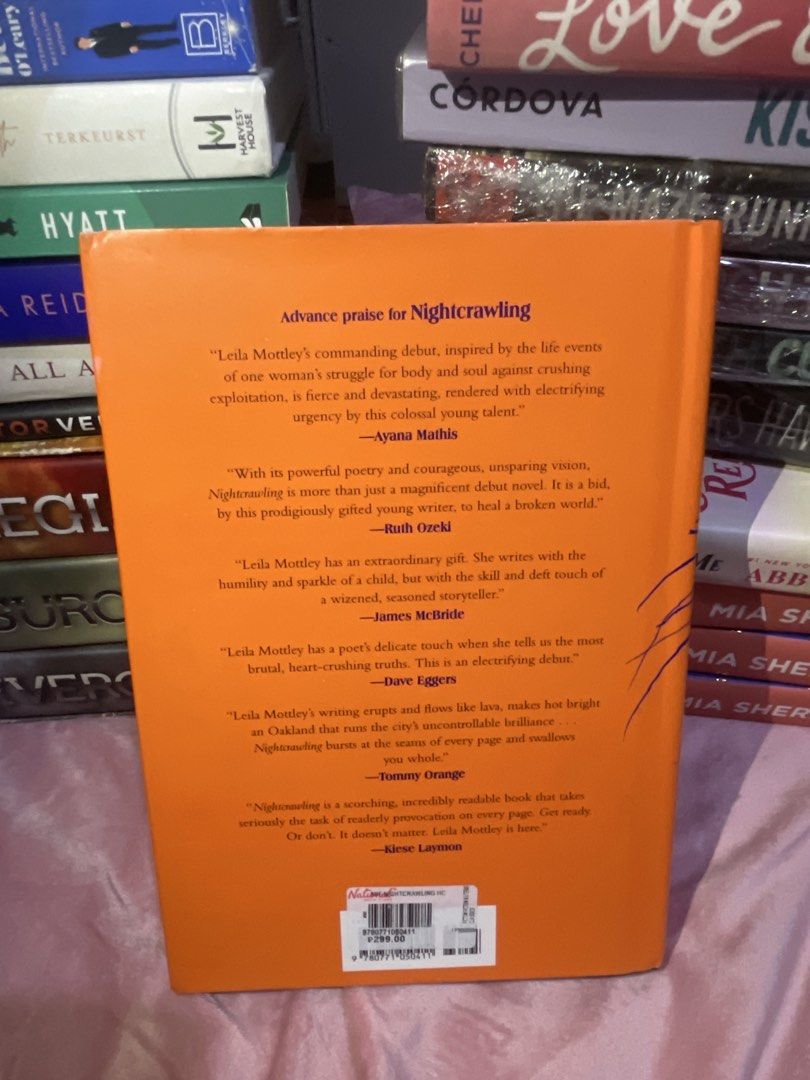 Nightcrawling by Leila Mottley Novel Hardcover (Category: Storybooks) located in San Fabian. Submitted by chloejeanyzarate (Listing ID 1469700739, Image 2). Description: - Title: Nightcrawling by Leila Mottley - Format: Hardcover edition - Design: Bright orange cover with striking blue illustration details - Special Features: Oprah's Book Club selection badge on the front and author praise quotes on the back - Condition: Clean pages, solid spine,