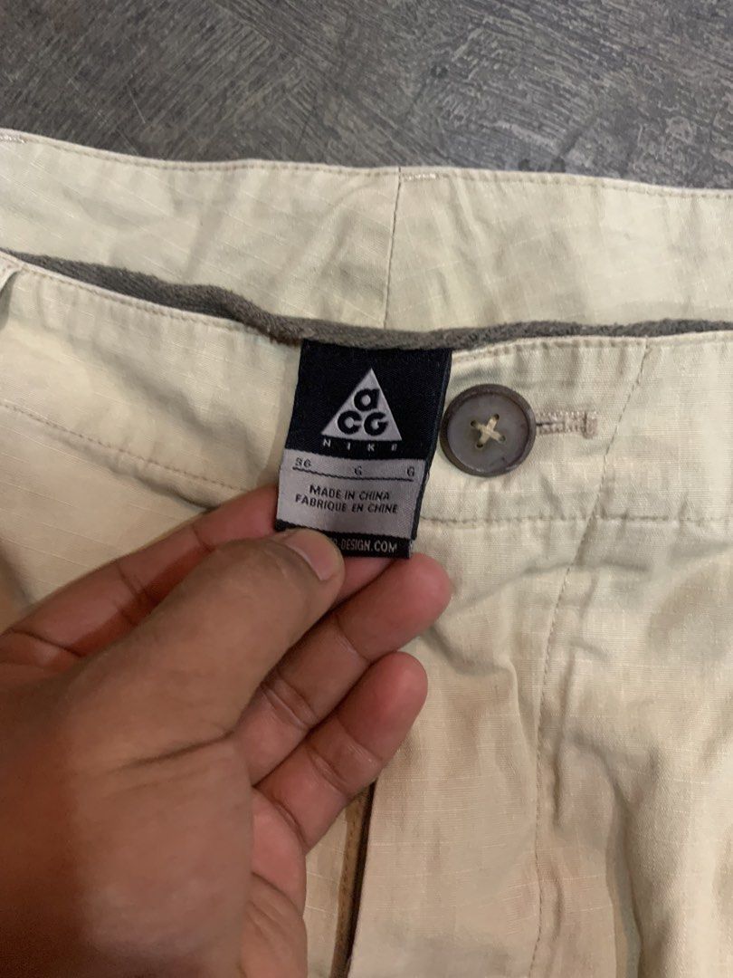 Nike ACG Beige Ripstop Cargo Pants Size 36 (Category: Joggers) located in Cagayan de Oro. Submitted by agboysalis60090 (Listing ID 1469709756, Image 3). Description: Nike ACG khaki beige pants in size 36. Button fly closure with multiple buttons down the front. Ripstop fabric texture. Classic ACG logo tag on the inside waistband and back exterior. Relaxed straight leg fit. Great vintage outdoor gear piece..