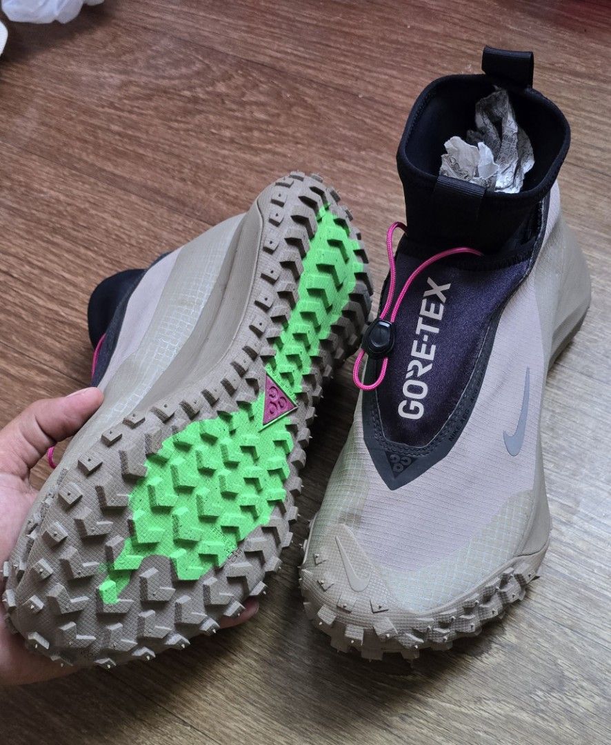 Nike ACG Mountain Fly Gore-Tex Khaki (Category: Sneakers) located in Quezon. Submitted by archivesss_666 (Listing ID 1469681011, Image 3). Description: - Brand: Nike ACG Mountain Fly - Colorway: Khaki and black with striking neon pink laces - Material: Waterproof Gore-Tex upper for ultimate weather protection - Closure: Quick-lace toggle system for easy adjustments - Sole: Chunky rubber sole equipped with green traction lugs for outdoor trails - 
