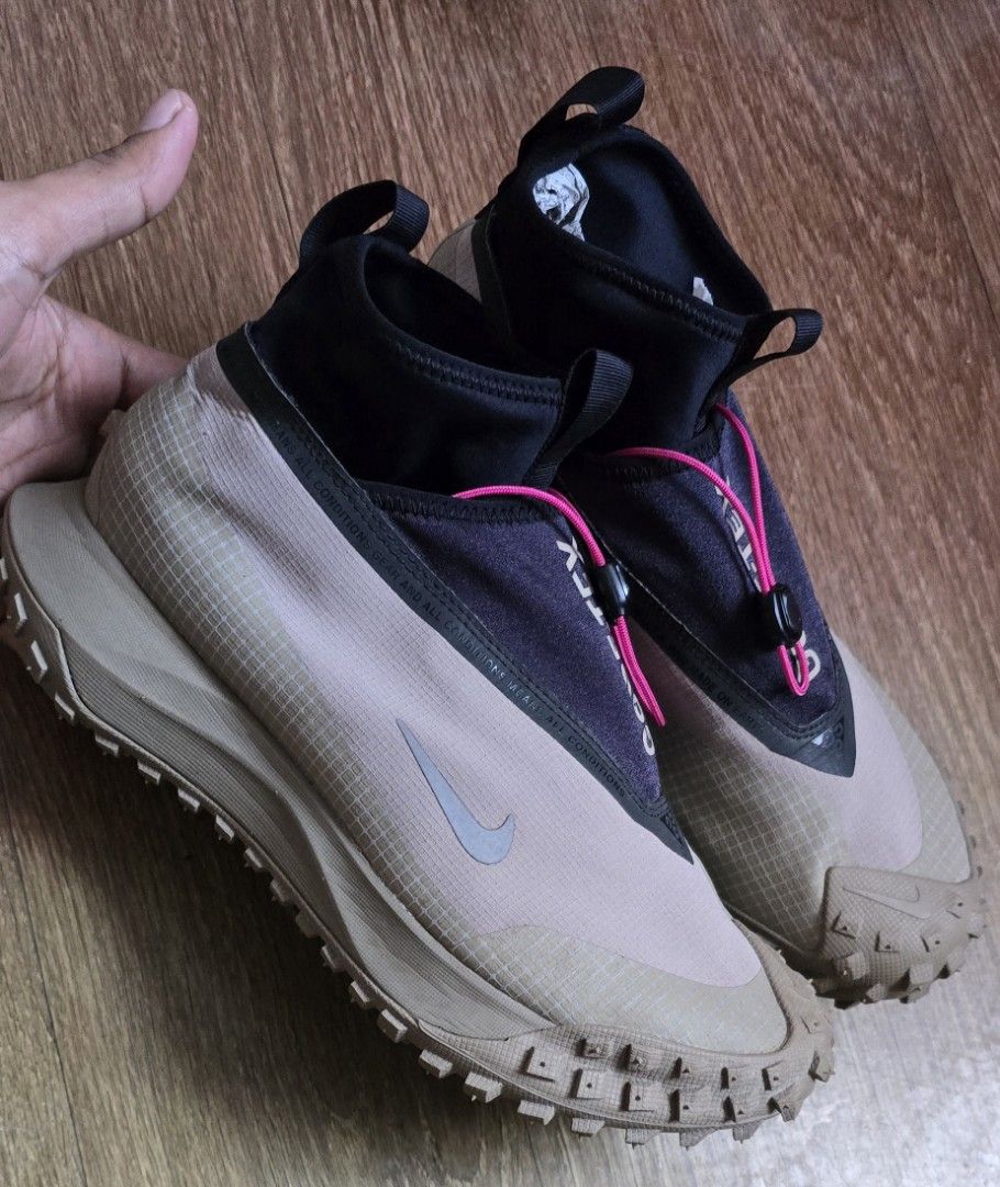 Nike ACG Mountain Fly Gore-Tex Khaki (Category: Sneakers) located in Quezon. Submitted by archivesss_666 (Listing ID 1469681011, Image 2). Description: - Brand: Nike ACG Mountain Fly - Colorway: Khaki and black with striking neon pink laces - Material: Waterproof Gore-Tex upper for ultimate weather protection - Closure: Quick-lace toggle system for easy adjustments - Sole: Chunky rubber sole equipped with green traction lugs for outdoor trails - 
