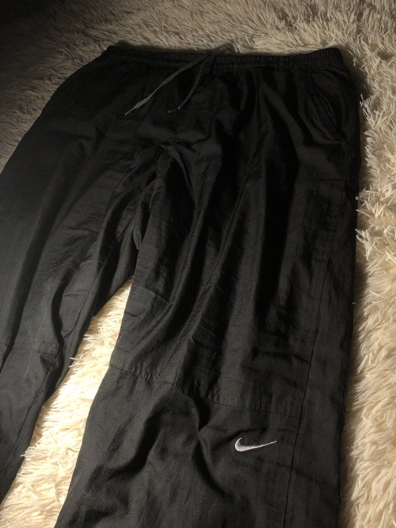Nike Black Nylon Track Pants 2XL (Category: Joggers) located in Maria Aurora. Submitted by kylerikathriftshop101010 (Listing ID 1469711676, Image 2). Description: freewaist 41 length 8.7 hem see pics issues:repairs di halata masyadon - Brand: Nike - Color: Black - Size: 2XL (Made in Korea) - Material: Lightweight nylon - Features: Elastic drawstring waistband, embroidered Nike swoosh near the knee - Condition: Pre-owned with minor surface snags a