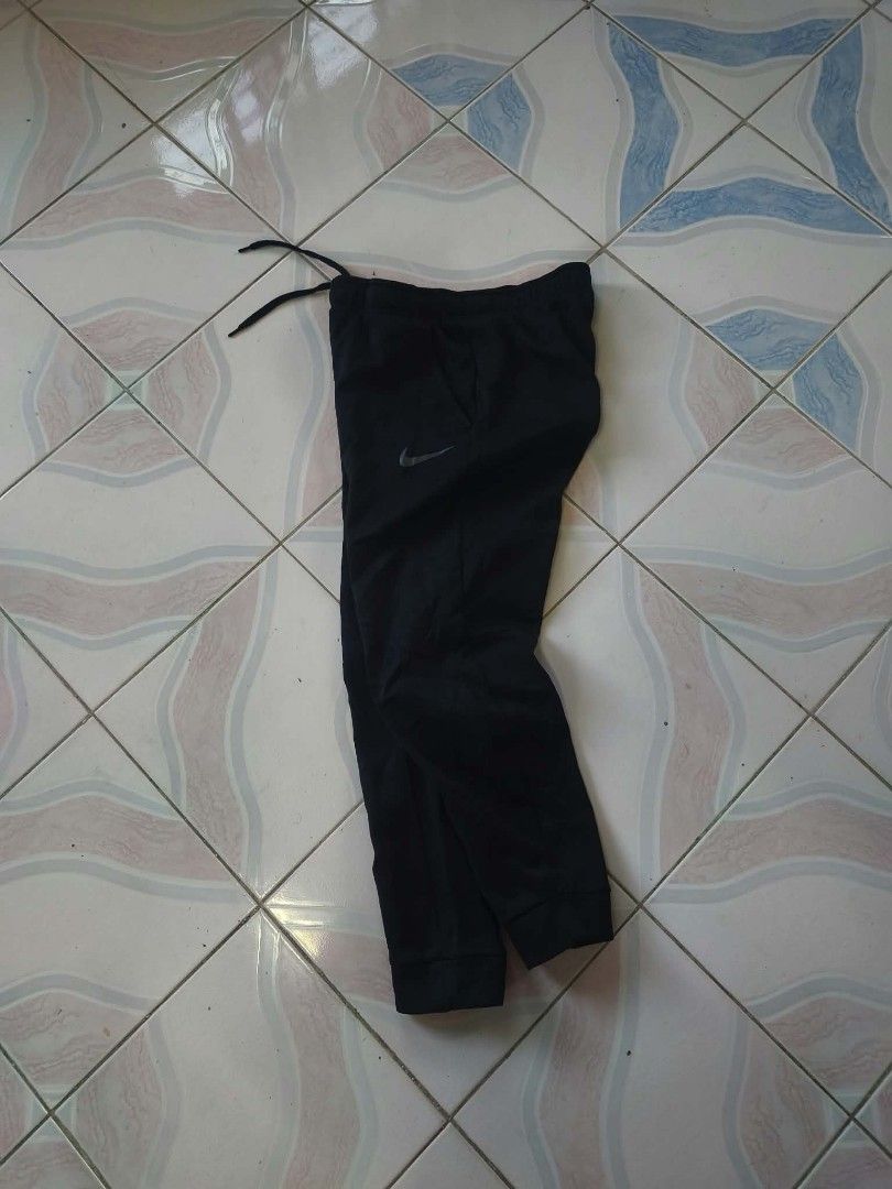Nike Dri-FIT Black Jogger (Category: Joggers) located in Manila. Submitted by cookthrift (Listing ID 1469573966, Image 2). Description: - Authentic Nike joggers in sleek black - Dri-FIT technology keeps you cool and dry - Size: Small to medium - Branded elastic waistband with adjustable inner drawstring - Classic grey Nike swoosh on the left leg - Comfortable cuffed hems at the bottom - Smooth, lightweight fabric ideal for workouts or everyday lo