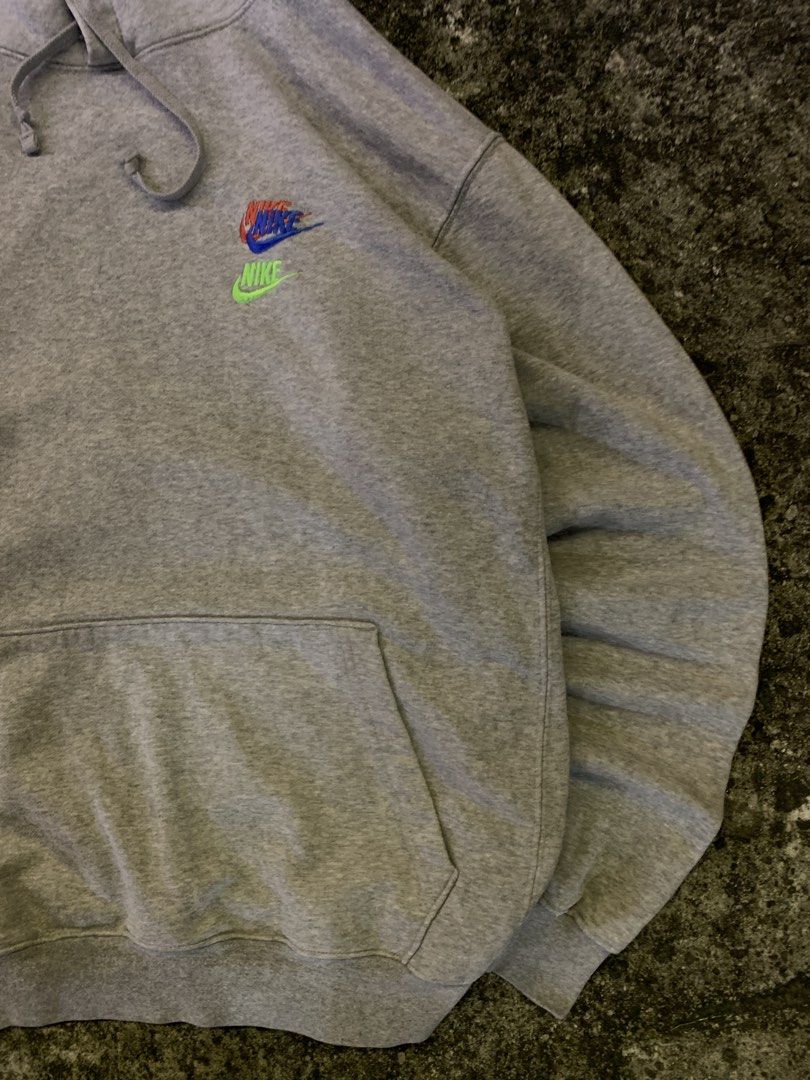 Nike Grey Multiple Logo Embroidered Pullover Hoodie (Category: Hoodies) located in Manila. Submitted by thrift2mnla (Listing ID 1469681243, Image 2). Description: Grey Nike hoodie with stacked multi-color embroidered logos on the chest, a white logo hit on the hood, and a lime green swoosh near the pocket hem. Standard drawstring hood and front pouch pocket. Heavyweight cotton fleece material, comfortable fit..