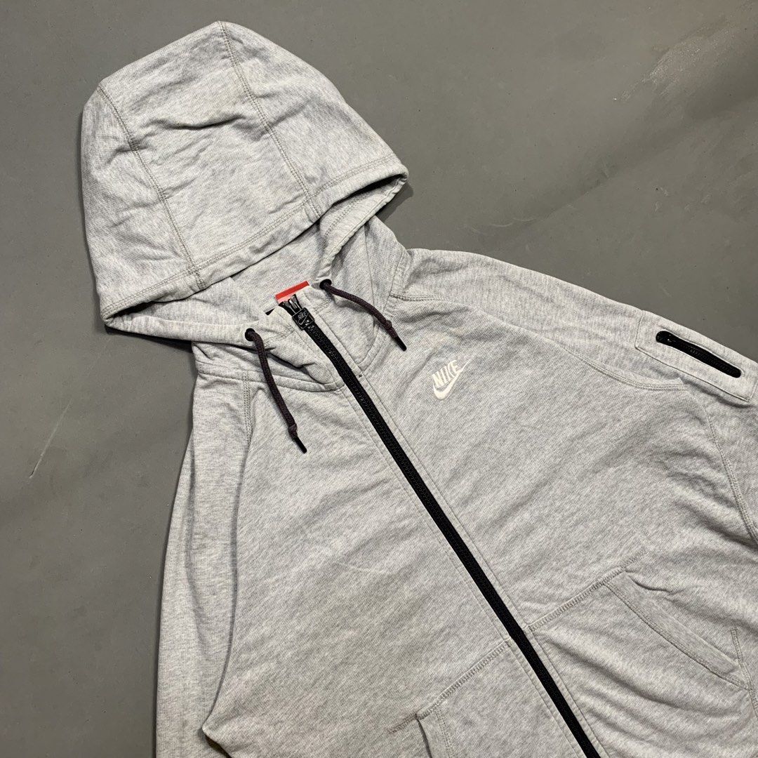 Nike Grey Zip-Up Hoodie (Category: Hoodies) located in Kalibo. Submitted by gneiss2002 (Listing ID 1469695697, Image 3). Description: - Authentic grey Nike zip-up hoodie - Material: Comfortable cotton with regular fit - Design: Full front zipper and adjustable drawstring hood - Branding: White embroidered Nike logo on the left chest - Storage: Two front pockets plus a secure zippered pocket on the left sleeve - Details: Ribbed cuffs for a snug fi