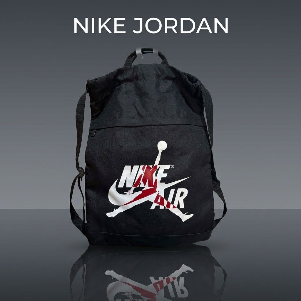 Nike Jordan Drawstring Backpack Black Red White (Category: Backpacks) located in Carmen. Submitted by ar_thrift00 (Listing ID 1469634747, Image 1). Description: - Nike Jordan drawstring backpack in black canvas - Bold red and white Jordan graphic on the front - Spacious main compartment with drawstring closure - Convenient carrying handle and adjustable shoulder straps - Breathable mesh back panel with embossed Jumpman logo - Clean inside and out