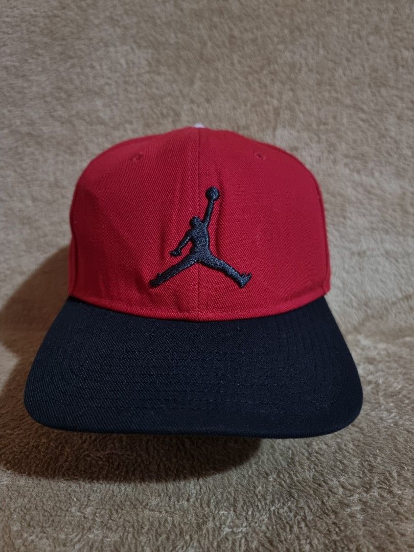 Nike Jordan Pro Jumpman Snapback Cap (Category: Caps & Hats) located in Imus. Submitted by aim_for_less (Listing ID 1469754643, Image 1). Description: Nike Jordan Pro Jumpman Snapback Cap - Brand: Jordan - Style: Classic two-tone snapback cap - Colors: Vibrant red crown with a black flat brim - Details: Iconic black embroidered Jumpman logo on the front - Fit: Adjustable snap closure at the back with small Jordan branding tab - Condition: Clean s
