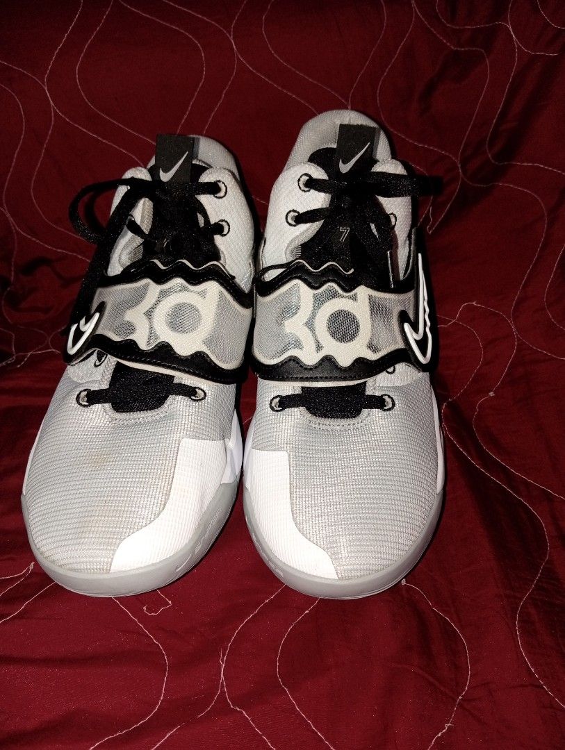 Nike KD Trey 5 IX White Black Grey (Category: Sneakers) located in Manila. Submitted by kramchelle (Listing ID 1469743348, Image 2). Description: - Brand: Nike Kevin Durant (KD) basketball shoes - Colorway: White and light grey mesh upper with black laces - Design: Iconic reverse swoosh on the lateral side, with KD logos on the tongue and heel - Performance: Equipped with responsive Zoom Air cushioning in the midsole .
