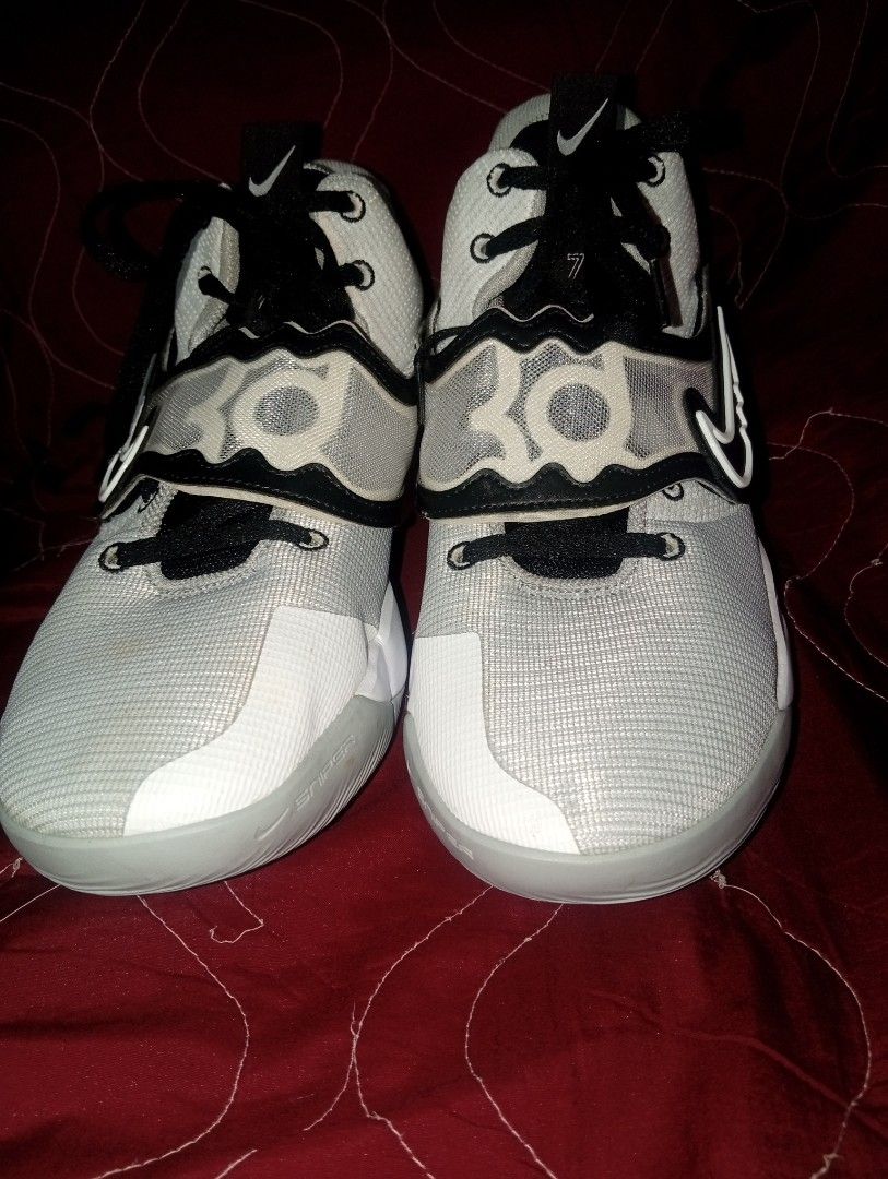 Nike KD Trey 5 IX White Black Grey (Category: Sneakers) located in Manila. Submitted by kramchelle (Listing ID 1469743348, Image 1). Description: - Brand: Nike Kevin Durant (KD) basketball shoes - Colorway: White and light grey mesh upper with black laces - Design: Iconic reverse swoosh on the lateral side, with KD logos on the tongue and heel - Performance: Equipped with responsive Zoom Air cushioning in the midsole .