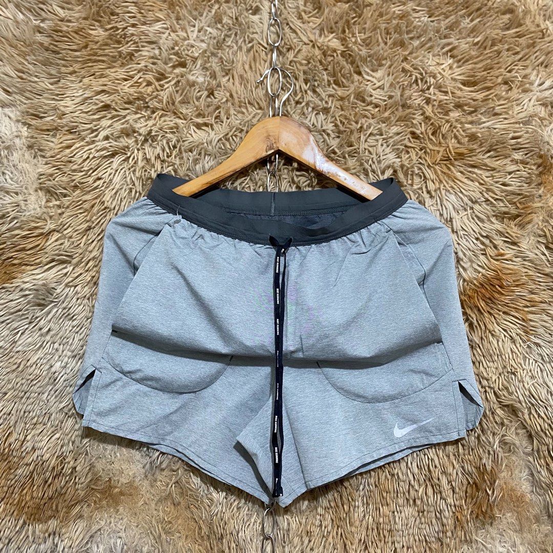 Nike Running Shorts Grey with Drawstring (Category: Shorts) located in Butuan. Submitted by jc13thrifts (Listing ID 1469752385, Image 1). Description: - Authentic grey Nike running shorts - Lightweight, breathable material - Elastic waistband with black Nike Running branded drawstring - Reflective swoosh logo on lower leg for visibility - Slit hems for maximum mobility - Secure back zippered pocket on the right hip - Clean condition, great for wo