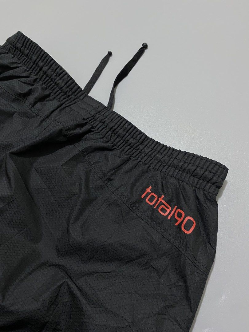 Nike Total 90 Black Track Pants (Category: Joggers) located in Manila. Submitted by urboycee (Listing ID 1469711280, Image 3). Description: - Brand: Nike Total 90 - Color: Black with orange accents - Size: Medium (M tag inside) - Features: Nike Fit Storm technology, adjustable drawstring waist, lower leg zippers - Branding: Printed T90 logo near waistband, small Swoosh and '90' graphic on front leg - Condition: Clean overall, well-maintained.