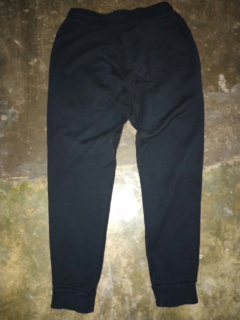 Nike Track & Field Cuff fleece sweatpants (Category: Activewear) located in Cavite. Submitted by adynnej.various.items (Listing ID 1469680552, Image 2). Description: featuring an elastic drawstring waist, side pockets, ribbed ankle cuffs, and a vintage-style Nike Futura logo with "TRACK & FIELD" text on the upper left leg. Have a bit of glitters on the back. W: 30-34, L: 38 Color Rate: 9/10.