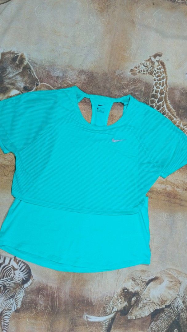 Nike Turquoise Athletic Top Size L (Category: Activewear) located in Cavite. Submitted by navias (Listing ID 1469627581, Image 1). Description: Origin:UAE 100% - Brand: Nike - Size: L - Color: Bright turquoise - Condition: Brand new with tags attached - Origin: Made in Malaysia - Material & Design: Lightweight ribbed fabric with a breathable racerback cutout - Extra Feature: Reflective swoosh logo on the front - Best For: Workouts, running, and c