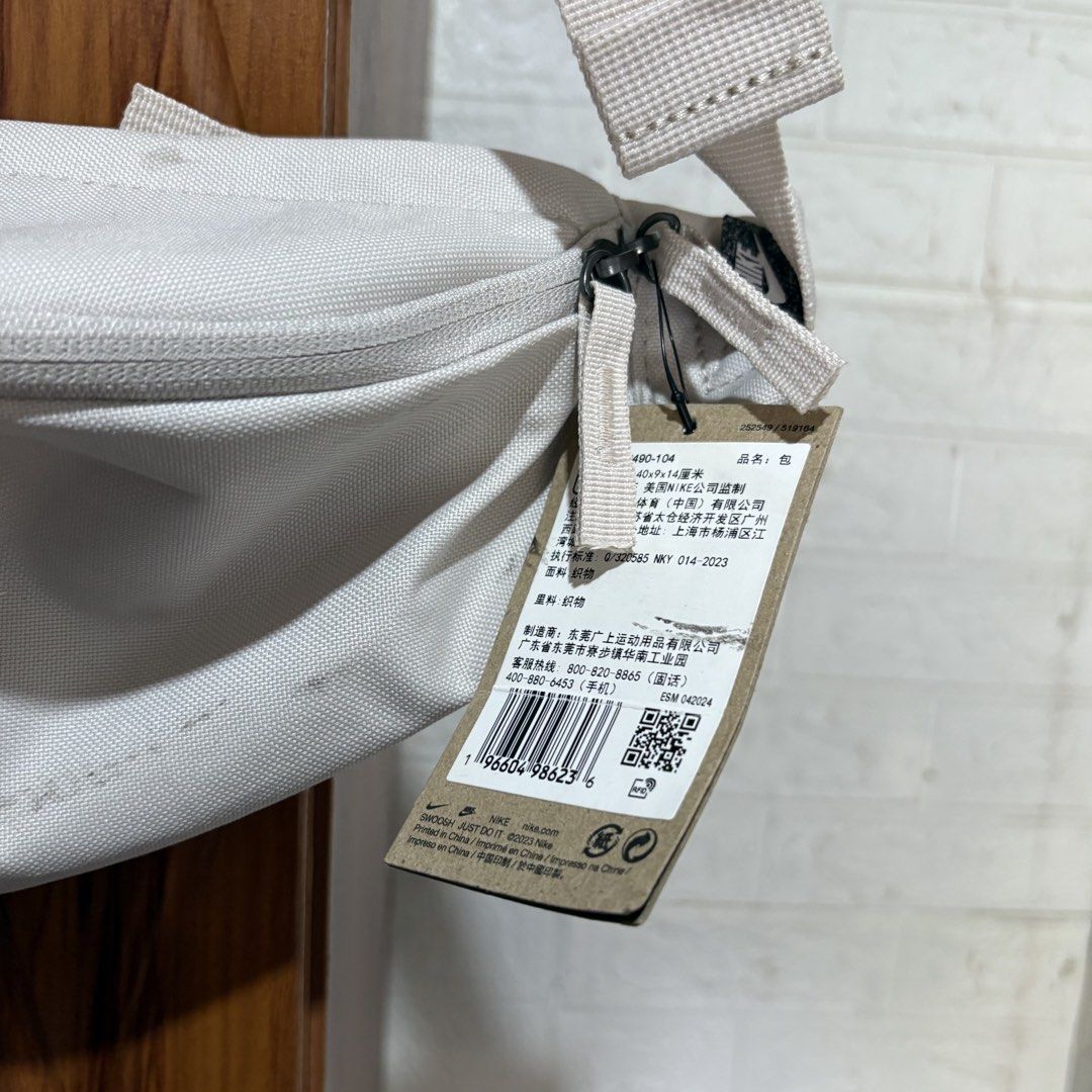 Nike Waist Pack DB0490 104 Off-White (Category: Cross-body Bags) located in Carmen. Submitted by rr_thrifts (Listing ID 1469687057, Image 2). Description: - Brand: Nike - Color: Off-white with large white logo - Style Code: DB0490 104 - Features: Adjustable strap, secure buckle closure, and zippered main compartment - Condition: Good functional condition with original paper hang tags still attached; please note need wash fresh from bale - Perfect