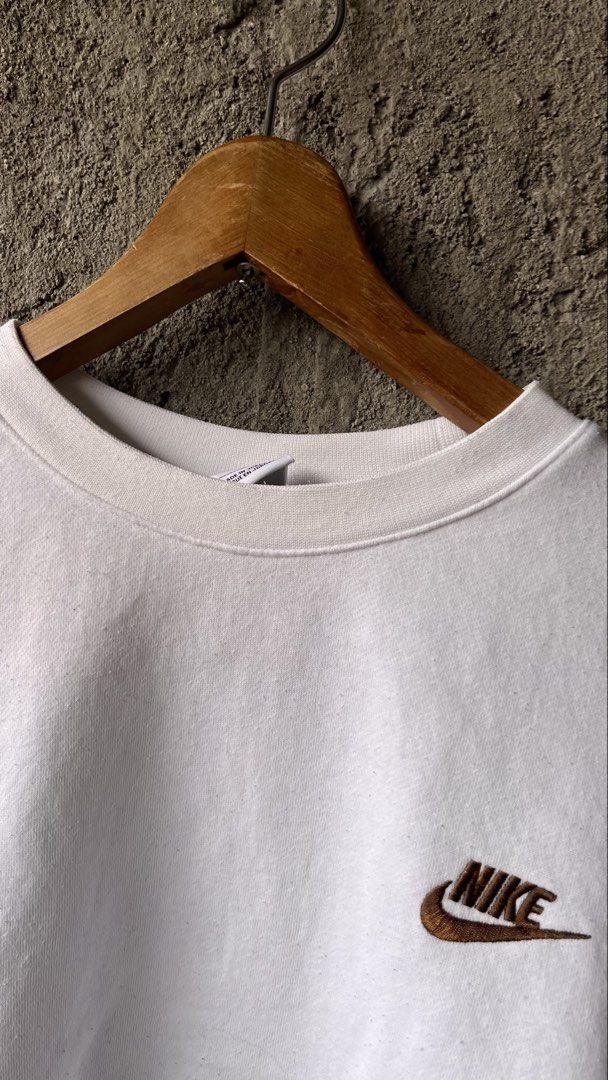 Nike White Brown Logo Embroidered Sweatshirt (Category: Coats, Jackets and Outerwear) located in Cabuyao City. Submitted by bulandos (Listing ID 1469581113, Image 3). Description: - Brand: Nike - Style: Crewneck sweatshirt with embroidered brown logo (Tag: BV2662-100) - Size: Large - Color: White - Material: 80% Cotton, 20% Polyester with cozy fleece interior lining - Origin: Made in Jordan - Fit: Classic fit, perfect for casual outfits.