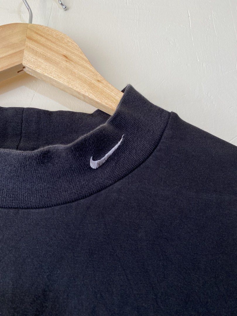 NIKE,Long-sleeve shirt (Category: Coats, Jackets and Outerwear) located in Cavite. Submitted by jc_thrift95 (Listing ID 1469665832, Image 3). Description: - a black long-sleeve top featuring a mock-neck collar and a small embroidered white Nike Swoosh logo on the upper chest. - Made in Singapore - L- 31 inch - W- 24 inch - Color rate 8/10 - See picture details for dimes. .
