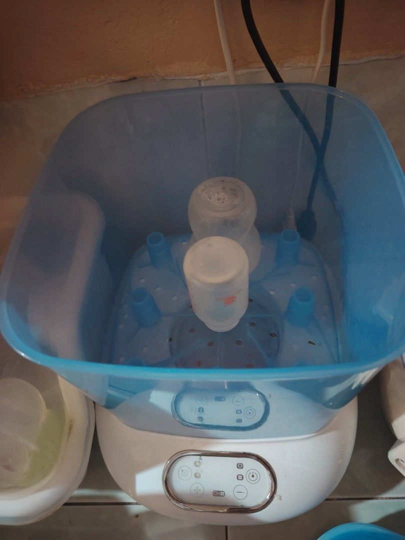 Nurture Electric Steam Sterilizer (Category: Breastfeeding & Bottle Feeding) located in Quezon City. Submitted by livebird_b3d174 (Listing ID 1469744452, Image 3). Description: - Brand: Nurture electric steam sterilizer - Color: White and blue with clear blue housing - Control: Modern digital control panel with easy touch buttons - Capacity: Holds multiple baby bottles and accessories securely on the internal rack - Purpose: Keeps feeding gear cl