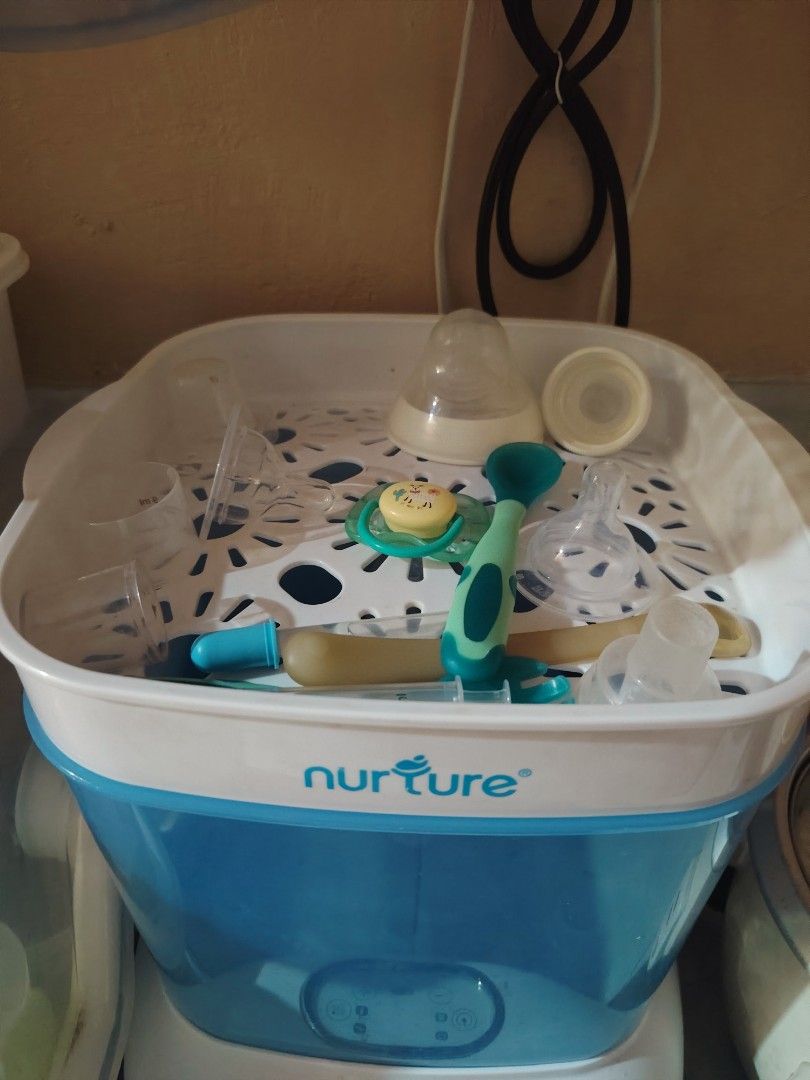 Nurture Electric Steam Sterilizer (Category: Breastfeeding & Bottle Feeding) located in Quezon City. Submitted by livebird_b3d174 (Listing ID 1469744452, Image 2). Description: - Brand: Nurture electric steam sterilizer - Color: White and blue with clear blue housing - Control: Modern digital control panel with easy touch buttons - Capacity: Holds multiple baby bottles and accessories securely on the internal rack - Purpose: Keeps feeding gear cl