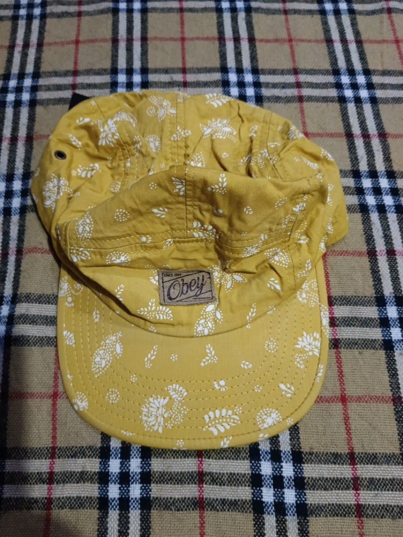 Obey Yellow Bandana Print 5-Panel Cap (Category: Caps & Hats) located in General Santos City (Dadiangas). Submitted by freehorse.5f2a61 (Listing ID 1469629708, Image 1). Description: - Brand: Obey - Style: 5-panel cap - Color/Pattern: Mustard yellow with white floral bandana print - Details: Brown stitched Obey logo patch on the front - Back Closure: Adjustable black nylon strapback with plastic buckle - Interior: Black fabric lining with yellow 