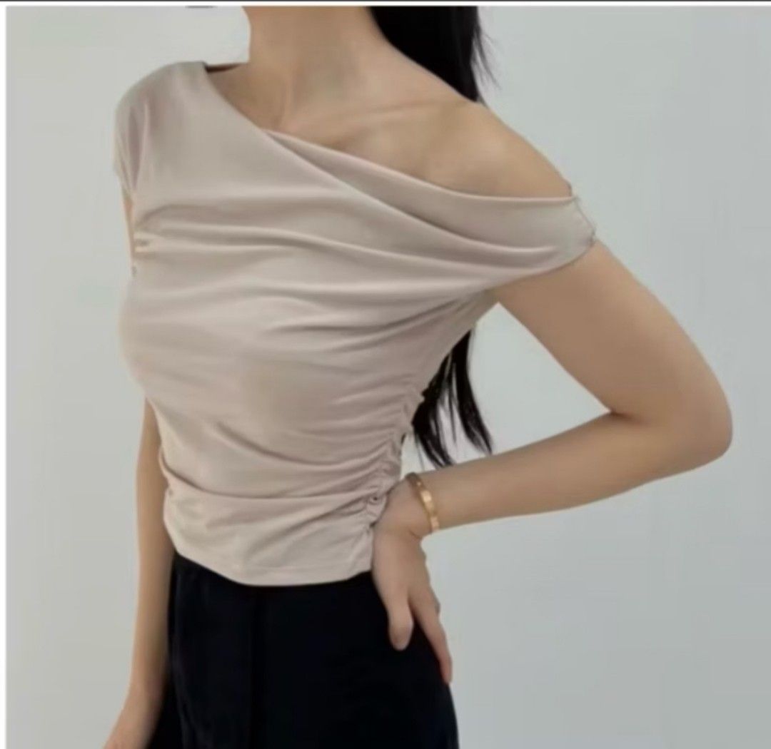 Off-shoulder draped beige top (Category: Blouses) located in Taguig. Submitted by chicstyle (Listing ID 1469676393, Image 1). Description: - Color: Beige - Style: Off-shoulder with asymmetric draped neckline and side ruching - Fit: Slim fit, soft and stretchy fabric for comfort - Sleeves: Short sleeves - Versatility: Easy to pair with jeans or trousers for casual or night out looks.