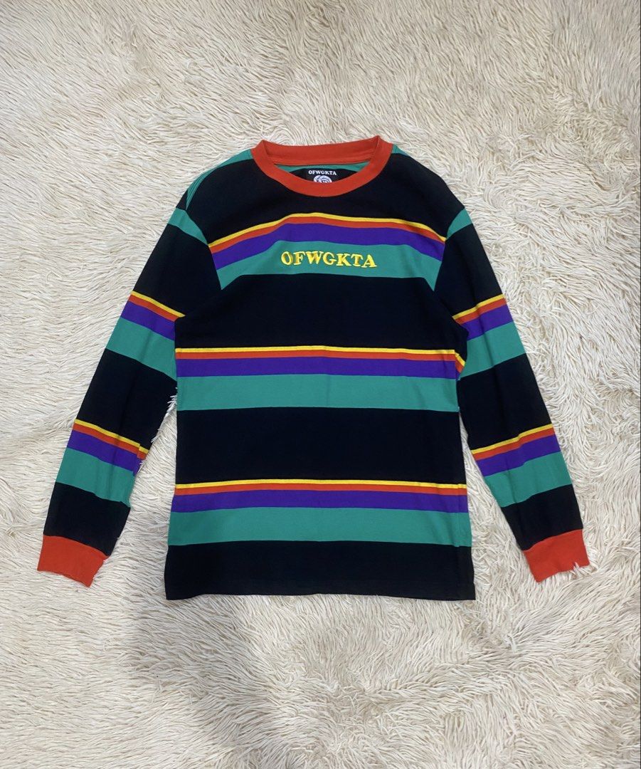 OFWGKTA Multi-color Striped Long Sleeve Tee (Category: Longsleeves) located in Antipolo. Submitted by switchneighborhood (Listing ID 1469653780, Image 1). Description: - Brand: OFWGKTA - Size: Medium (includes signature donut tag) - Design: Horizontal rainbow stripes (black, green, purple, orange, yellow) with embroidered chest logo - Details: Contrast orange ribbed collar and cuffs - Material: Thick, high-quality cotton, standard crew neck fit -