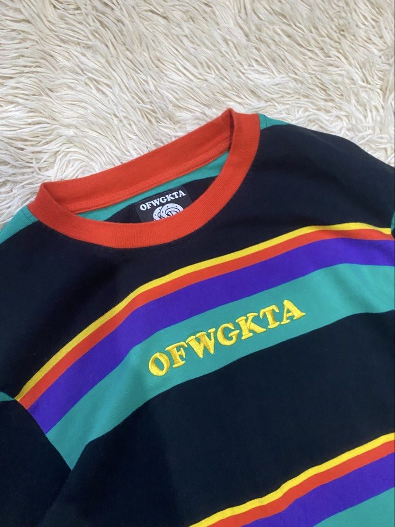 OFWGKTA Multi-color Striped Long Sleeve Tee (Category: Longsleeves) located in Antipolo. Submitted by switchneighborhood (Listing ID 1469653780, Image 2). Description: - Brand: OFWGKTA - Size: Medium (includes signature donut tag) - Design: Horizontal rainbow stripes (black, green, purple, orange, yellow) with embroidered chest logo - Details: Contrast orange ribbed collar and cuffs - Material: Thick, high-quality cotton, standard crew neck fit -