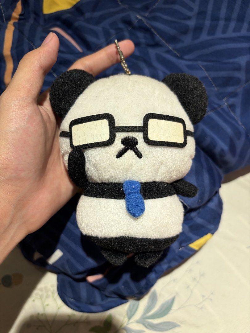 Ojisan Panda plush keychain with glasses (Category: Plushies & Soft Toys) located in Makati City. Submitted by squishycorner (Listing ID 1469714380, Image 1). Description: - Adorable Ojisan Panda design wearing glasses and a blue tie - Made with ultra-soft, huggable fabric - Equipped with a sturdy silver ball chain for easy hanging - Features a small tag at the back - Perfect cute accessory for your bags, backpacks, or keys.