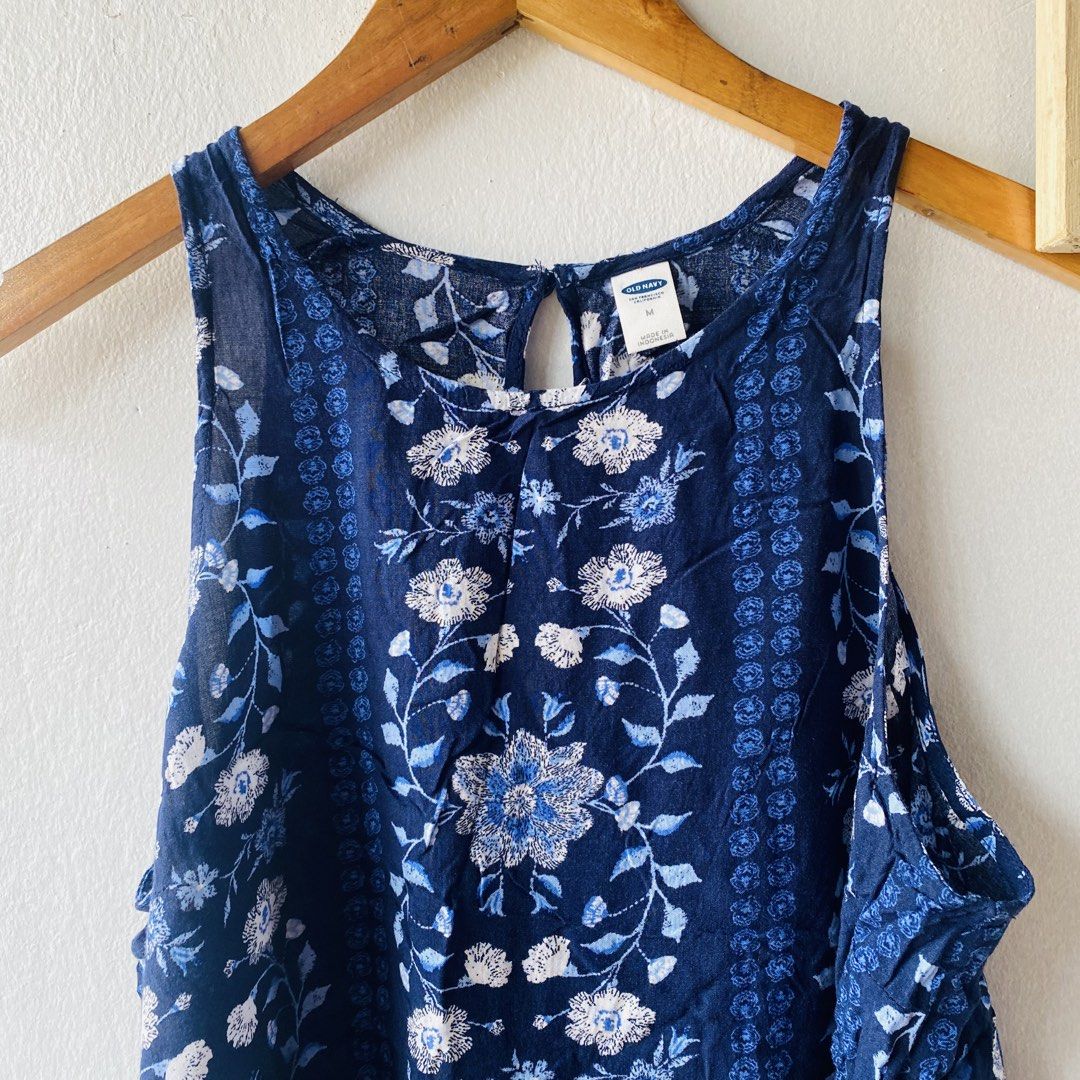 Old Navy Blue Floral Top (Category: Sleeveless) located in Caloocan City. Submitted by lovemyclothes21 (Listing ID 1469618276, Image 2). Description: - Brand: Old Navy - Size: Medium - Color: Blue with all-over floral and botanical pattern - Style: Sleeveless tank top with vertical border print details - Closure: Keyhole button closure at the back neckline - Material: Lightweight and breathable fabric, ideal for warm weather - Condition: Excellen
