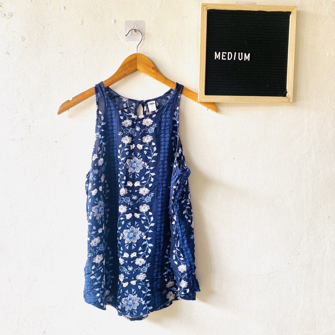 Old Navy Blue Floral Top (Category: Sleeveless) located in Caloocan City. Submitted by lovemyclothes21 (Listing ID 1469618276, Image 1). Description: - Brand: Old Navy - Size: Medium - Color: Blue with all-over floral and botanical pattern - Style: Sleeveless tank top with vertical border print details - Closure: Keyhole button closure at the back neckline - Material: Lightweight and breathable fabric, ideal for warm weather - Condition: Excellen
