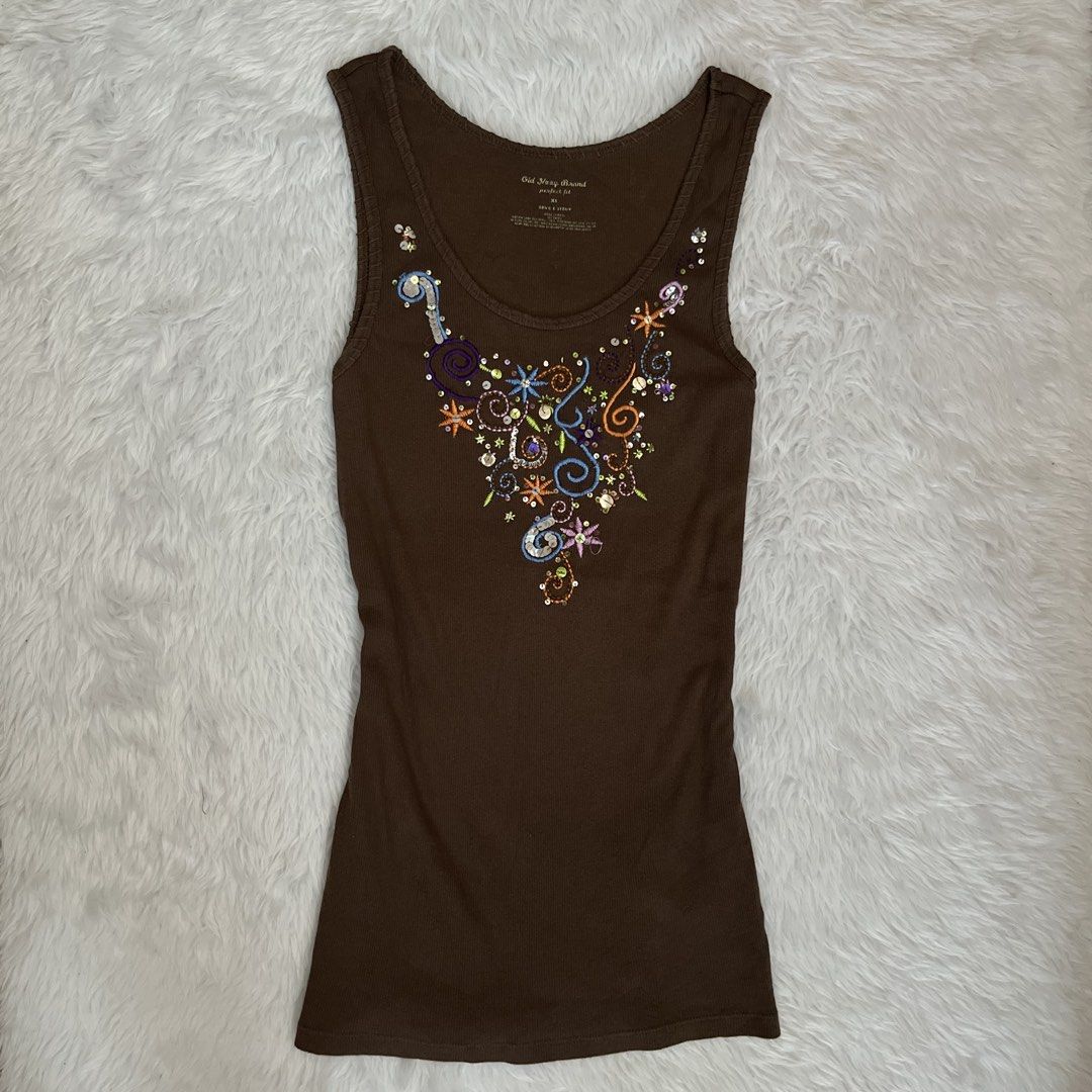 Old Navy Brown Tank Top with Embroidered Sequin Design (Category: Sleeveless) located in Maasin. Submitted by taraa18 (Listing ID 1469583746, Image 1). Description: - Brand: Old Navy - Size: Extra Small (XS) - Color: Brown - Style: Ribbed tank top with scoop neckline and fitted cut - Details: Multicolored chest embroidery with subtle sequin accents - Condition: Great for casual wear or layering in warm weather.
