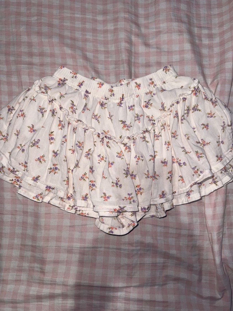 Old Navy Floral Ruffle Skort Size 4T (Category: Babies & Kids Fashion) located in Marikina City. Submitted by mvmaggie (Listing ID 1469587084, Image 1). Description: - Brand: Old Navy - Size: 4T - Design: White with small purple and pink floral print - Features: Easy elastic waistband, built-in shorts, and layered ruffle skirt design - Material: Shell (55% cotton, 45% rayon), Lining (100% cotton) - Care: Machine washable - Condition: Great for pl
