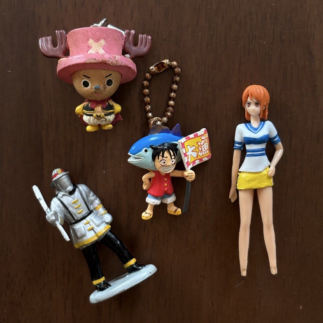 One Piece Anime Figures and Keychains Lot (Category: Figurines & Statues) located in Manila. Submitted by aobacafe (Listing ID 1469679262, Image 1). Description: - Lot of 4 One Piece miniature collectibles - Includes Tony Tony Chopper strap charm, Monkey D. Luffy fish costume keychain, Nami mini figure, and a silver armor knight figure - Condition: Shows paint wear, scuffs, and aging from storage - Ideal for desk decor or starting a small collect