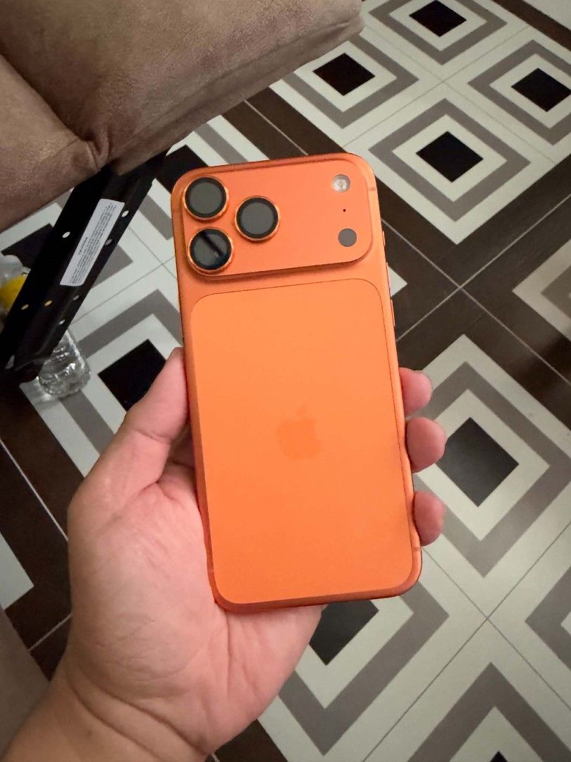Orange iPhone with Casetify Cat Case (Category: iPhone 17 Series) located in General Trias. Submitted by curiouskid24 (Listing ID 1469687502, Image 2). Description: - Color: Bright Orange body with a custom wallpaper - Condition: Working great, minor dent on the top corner frame - Battery Health: 92% (469 cycle count) - Camera: Triple camera setup on the back - Inclusion: Bundled with a colorful Casetify case worth 4.5K featuring cartoon cat grap