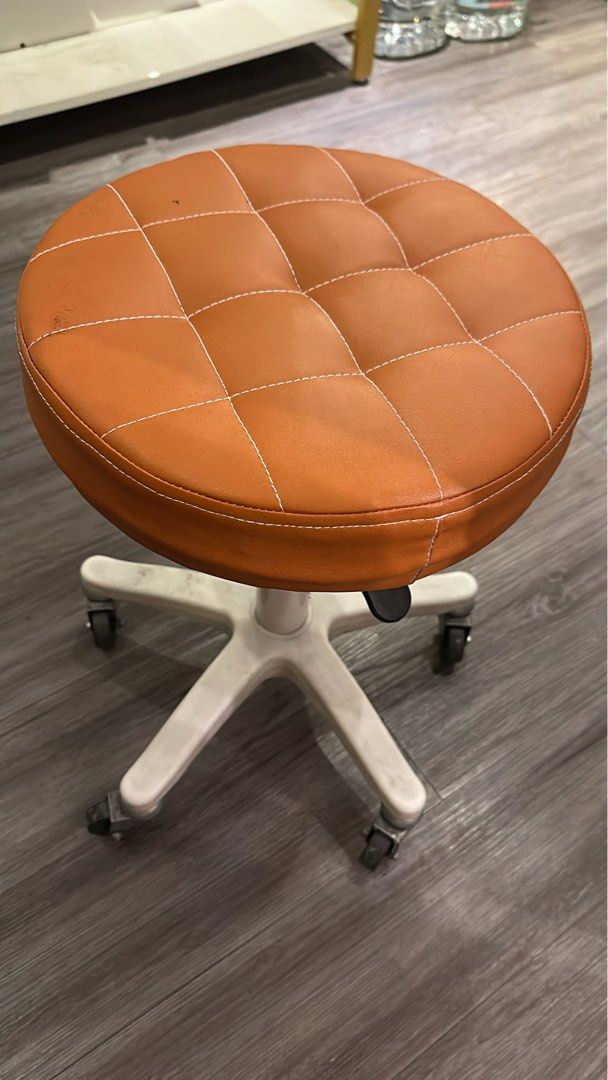Stool （分類：椅子）位於 Hong Kong。 由 spa208 提交（商品編號 1469647565，圖片 1）。簡介： Orange faux leather rolling stool with white five-star base and smooth caster wheels. Padded round seat featuring white contrast stitching in a grid pattern. Built-in lever underneath for height adjustment. Compact size, easy to roll around the office or vanity desk. Some minor scuffs and marks on the seat surface and legs from normal use. Fully functional height mechanism.。