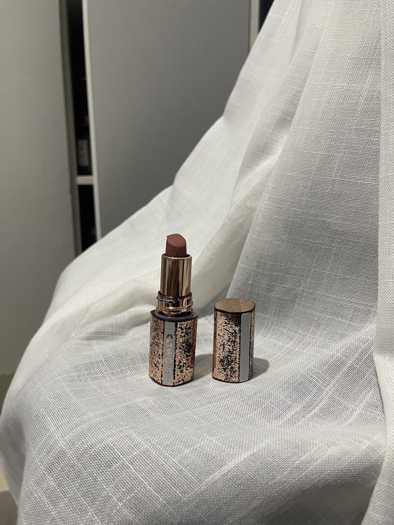 O.TWO.O Matte Lipstick Rose Gold (Category: Makeup) located in Caloocan City. Submitted by decluttering.101_ (Listing ID 1469661321, Image 1). Description: - Brand: O.TWO.O - Finish: Matte - Shade: Brownish nude - Packaging: Rose gold metallic with a speckled pattern - Condition: Lightly used at the top, cap is off in photos - Size: Handy and perfect for makeup pouches.