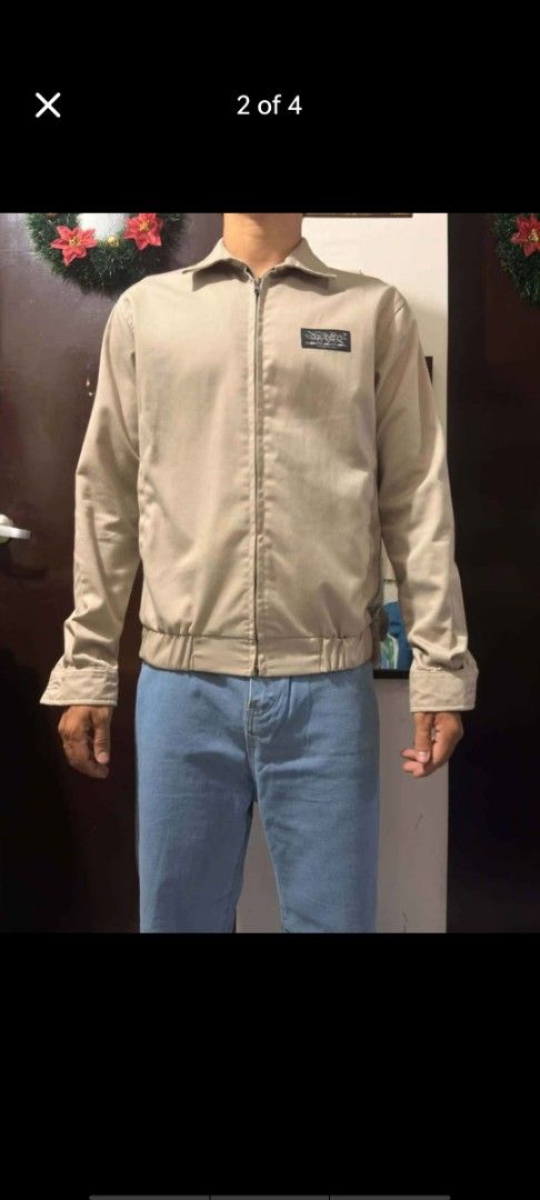 OXGN Beige Oxford Jacket with Back Print (Category: Coats, Jackets and Outerwear) located in Manila. Submitted by billythekid05 (Listing ID 1469720232, Image 1). Description: - Color: Neutral beige - Style: Zip-up jacket with a collared neck and elastic waistband - Details: Small black logo patch on the chest pocket area - Back Design: Large 'INSPIRED BY THE WORLD' text print - Cuffs: Buttoned for an adjustable fit - Quality: Clean fabric and sol