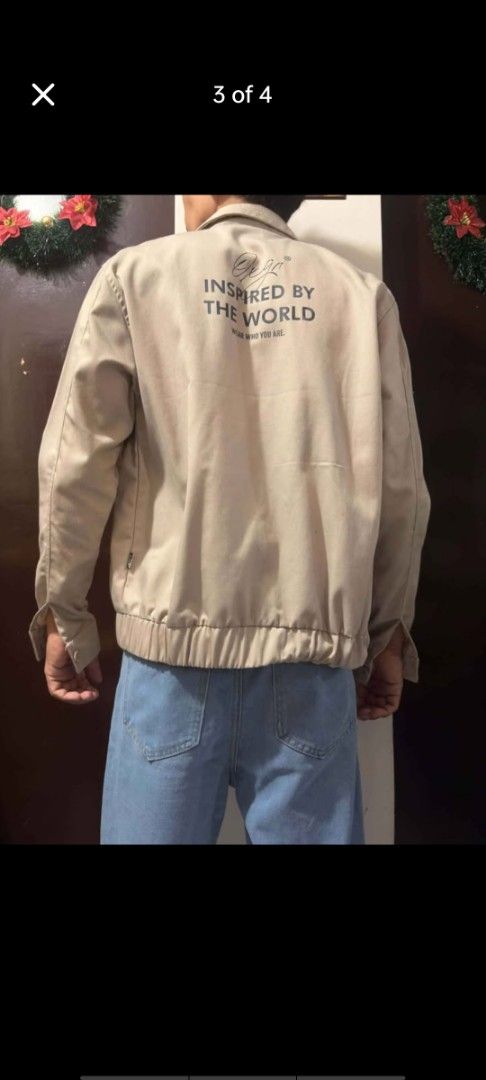 OXGN Beige Oxford Jacket with Back Print (Category: Coats, Jackets and Outerwear) located in Manila. Submitted by billythekid05 (Listing ID 1469720232, Image 3). Description: - Color: Neutral beige - Style: Zip-up jacket with a collared neck and elastic waistband - Details: Small black logo patch on the chest pocket area - Back Design: Large 'INSPIRED BY THE WORLD' text print - Cuffs: Buttoned for an adjustable fit - Quality: Clean fabric and sol