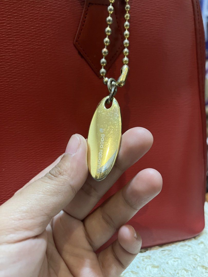 Paco Rabanne Red Leather Handbag (Category: Luxury Bags & Wallets) located in Bacolod City. Submitted by vintage_vogue6100 (Listing ID 1469672489, Image 2). Description: - Brand: Paco Rabanne - Material: Premium red textured leather - Hardware: Gold-tone with hanging metal charm tag on a beaded chain - Closure: Secure zip top - Handles: Dual structured top handles - Compartment: Interior storage for daily essentials - Measurements: 33cm (L) x 22c