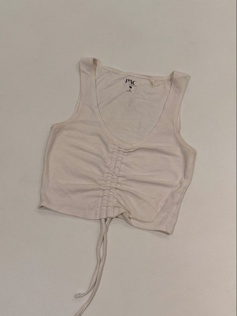 PacSun White Ruched Crop Tank Top (Category: Sleeveless) located in Muntinlupa City. Submitted by henlo03 (Listing ID 1469611455, Image 1). Description: - Brand: PacSun - Color: White - Size: XS - Material: Eco-friendly fabric line - Design: Scoop neckline with adjustable center ruching string - Condition: Worn a few times, washed, and carefully stored - Perfect for: Layering or wearing alone on warm days.