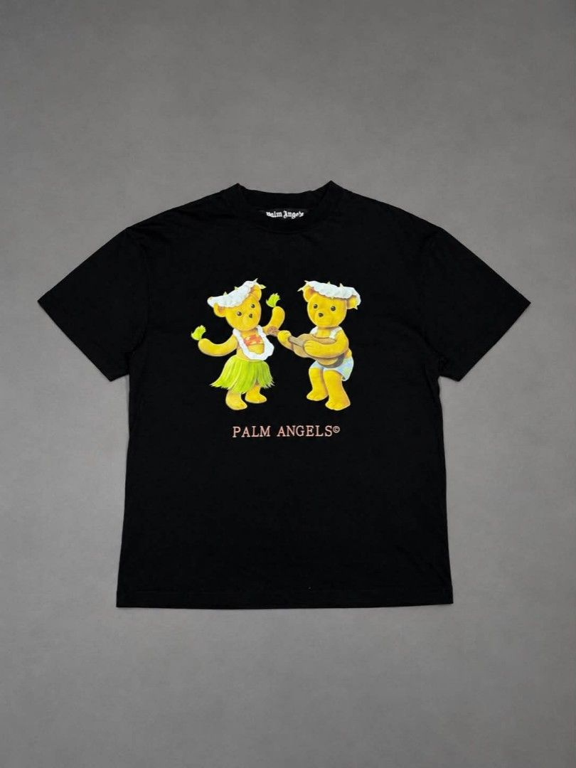 Palm Angels Hula Bears Black Tee Size S (Category: Shirts) located in Urdaneta. Submitted by jayceegarage (Listing ID 1469546479, Image 1). Description: Black cotton t-shirt from Palm Angels. Graphic print on the chest with two hula bears playing music. Pink Palm Angels logo underneath. Ribbed crew neck collar. Size small tag attached inside. Care and composition labels intact. with issue check last photo super visible issue unnoticeable po.