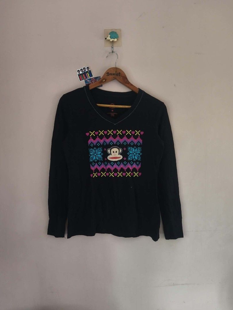 Paul Frank Black Long Sleeve (Category: Longsleeves) located in Manila. Submitted by cookthrift (Listing ID 1469576009, Image 1). Description: - Brand: Paul Frank - Style: Black long sleeve V-neck shirt with contrast stitching - Design: Iconic Julius the Monkey face graphic with colorful winter patterns (snowflakes, hearts, zig-zags) - Size: Medium (M) - Material: Comfortable cotton blend - Condition: Pre-loved, well-maintained - Perfect for casu